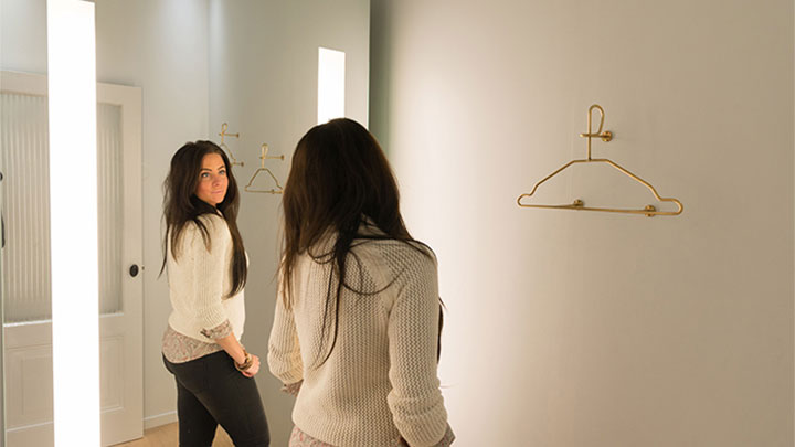 A SuperTrash customer checks her reflection in Philips' AmbiScene Mirror, on the "Day" light setting