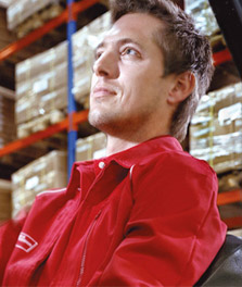 Male worker operates a forklift in a sustainable warehouse. - retail lighting 