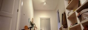 "Bright entryway with LED recessed lighting illuminating shelves, toys, and a children's balance bike."